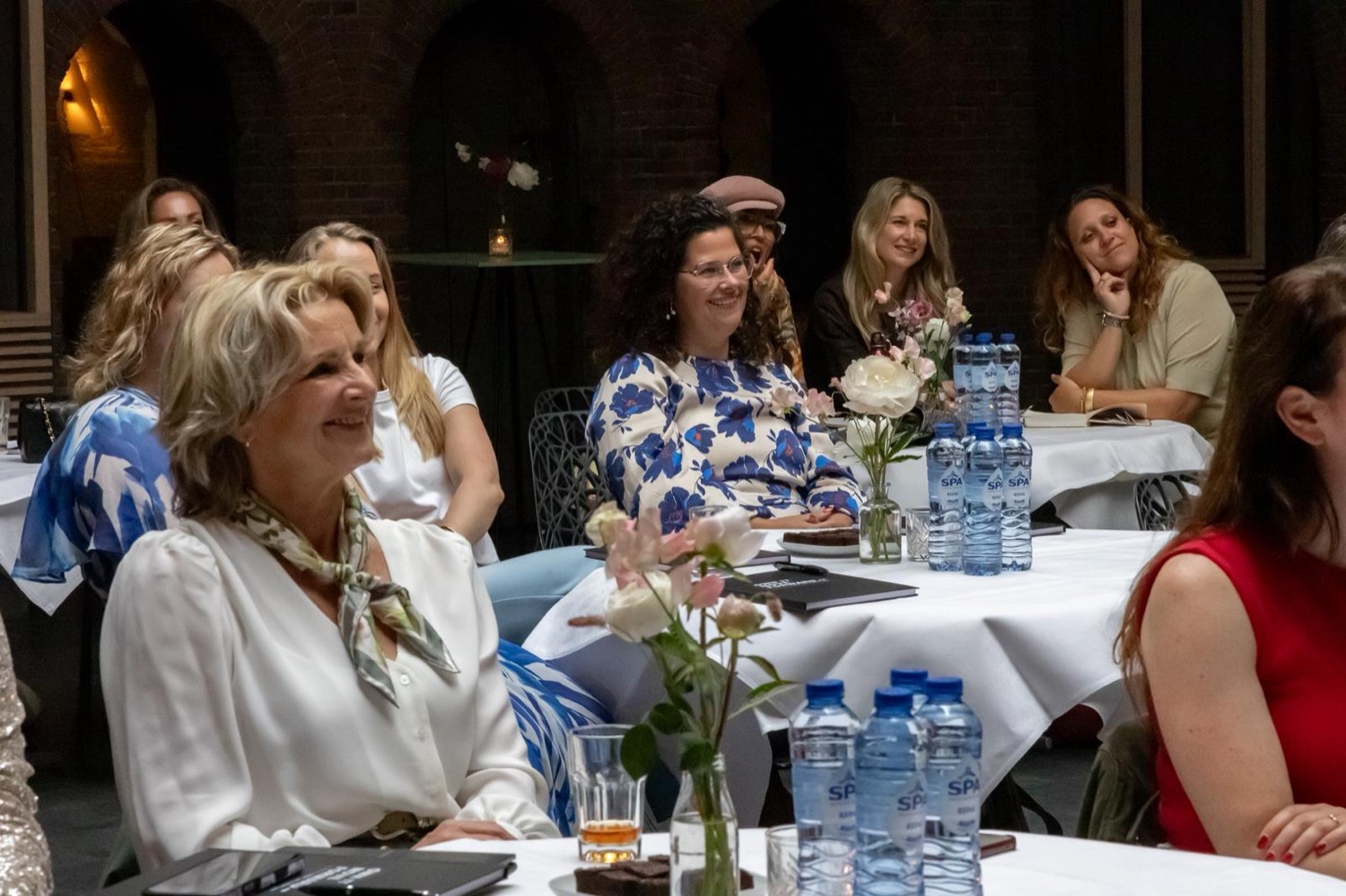 Deelnemers aan een Smartgirls-sessie, lachend aan tafel
