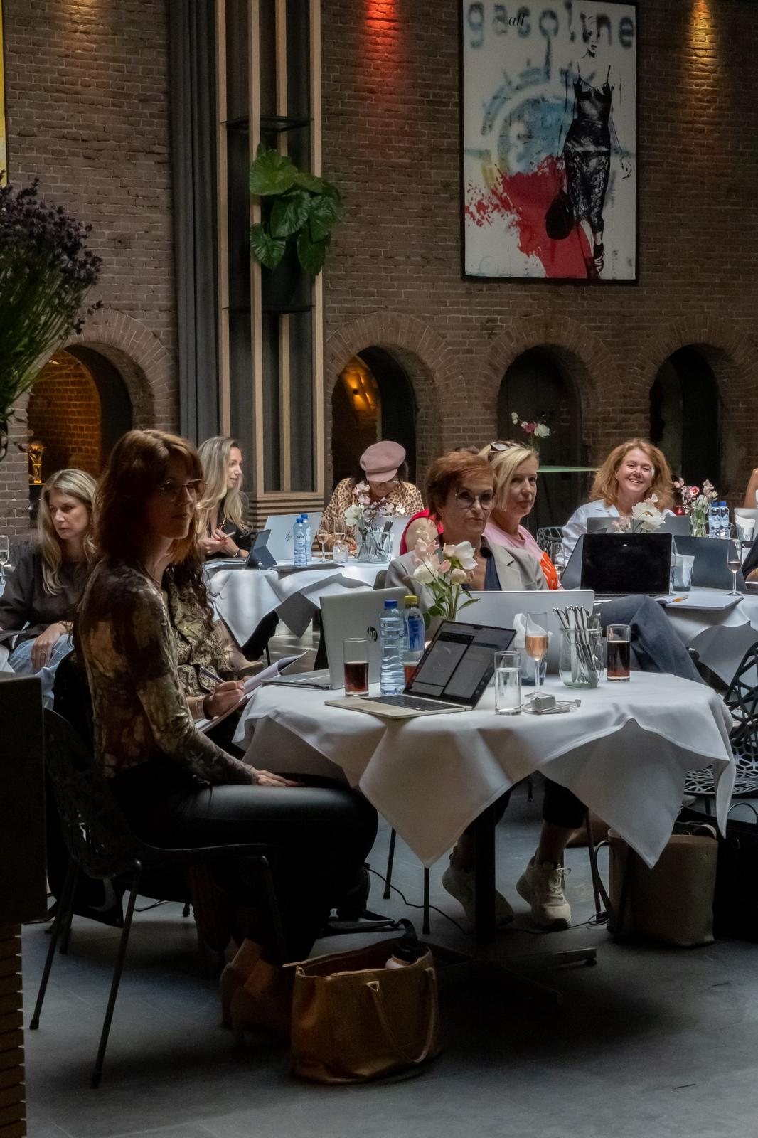 De zaal vol ondernemers met hun laptop open tijdens de AI-ochtend